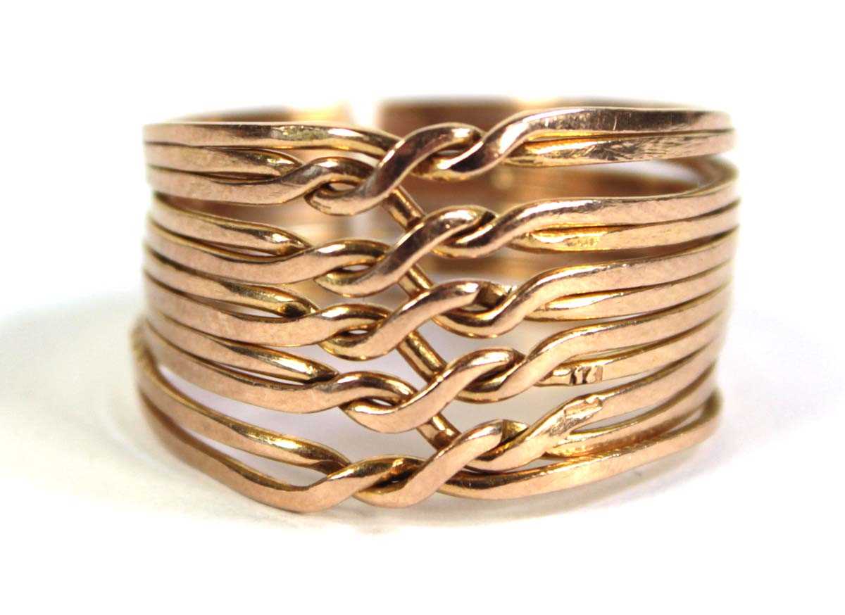 Lot 518 - A yellow metal eleven section puzzle ring,...