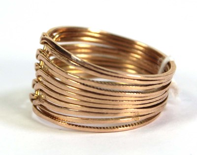 Lot 518 - A yellow metal eleven section puzzle ring,...