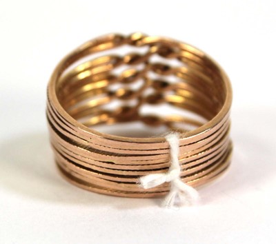 Lot 518 - A yellow metal eleven section puzzle ring,...