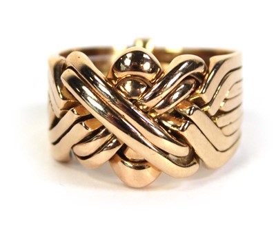 Lot 519 - A yellow metal eight section puzzle ring, ring...