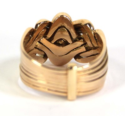 Lot 519 - A yellow metal eight section puzzle ring, ring...