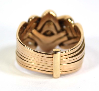 Lot 519 - A yellow metal eight section puzzle ring, ring...