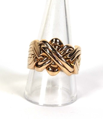 Lot 519 - A yellow metal eight section puzzle ring, ring...